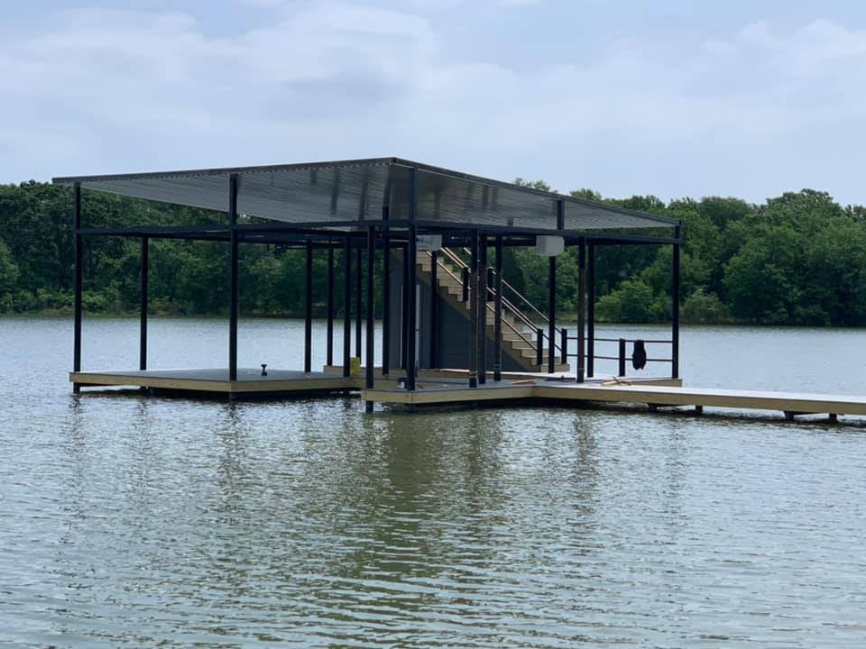 Side angle view of a custom boat ramp and deck pictured with stairs on the water