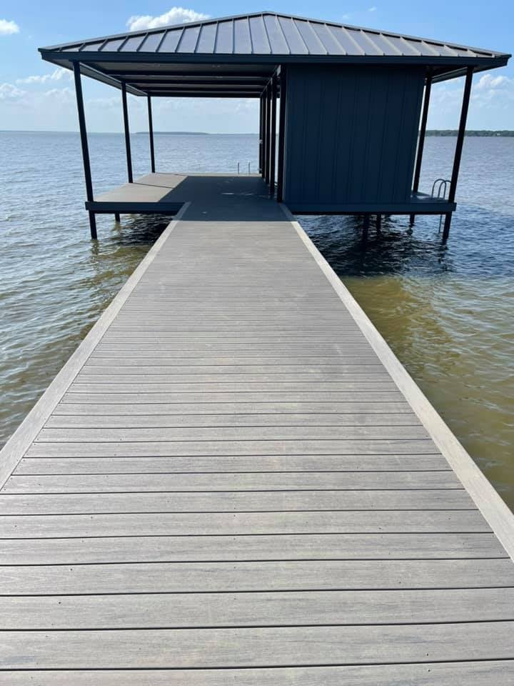 Walkway of a deck leading to a covered boat house with stairs that go down into the water